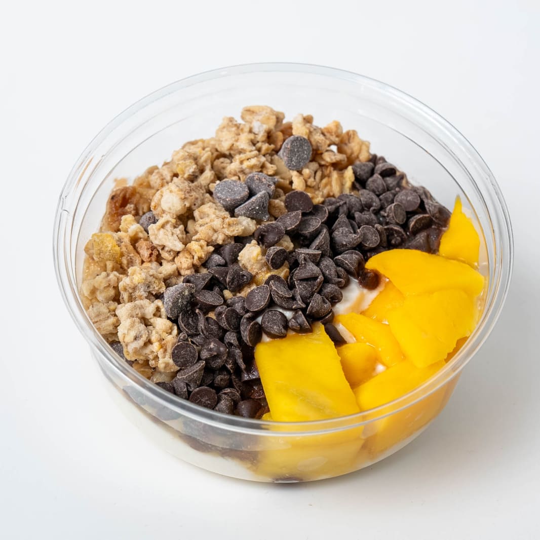 Poke bowl con arroz, pepino, surimi y mango sobre un fondo colorido